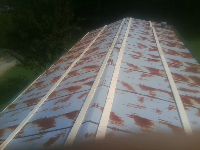 Rusted metal roof panels with new wood purlins before replacement — Storm Damage Roof Repair in Murdock by Roofing Brothers