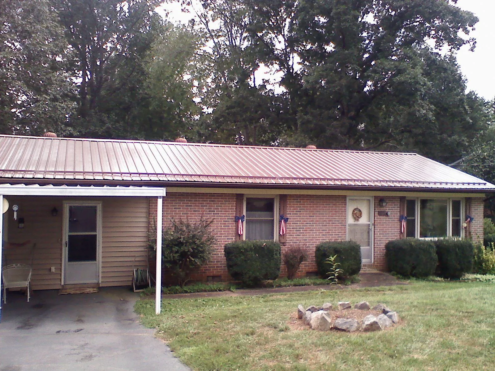 Bronze metal roof and carport on a brick ranch home — Roof Repair work by our crew in Murdock